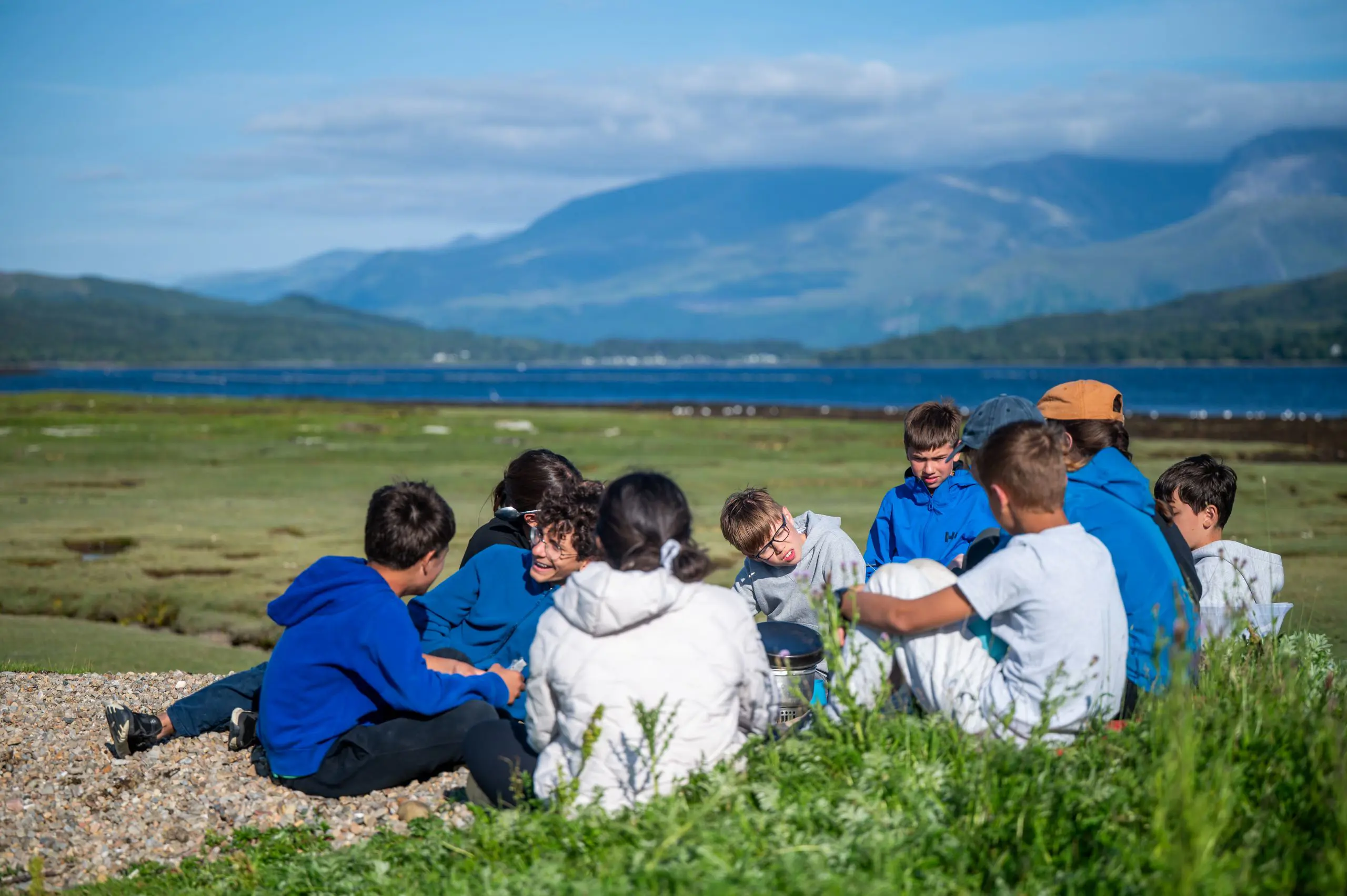Two students on Gordonstoun International Summer School Camp in the Scottish Mountains walking through long grass